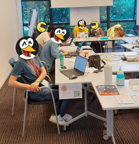 Une photo prise durant l'install party des jdll 2025. Les visages sont remplacés par des têtes de manchots hilares et des smileys avec des lunettes noires.